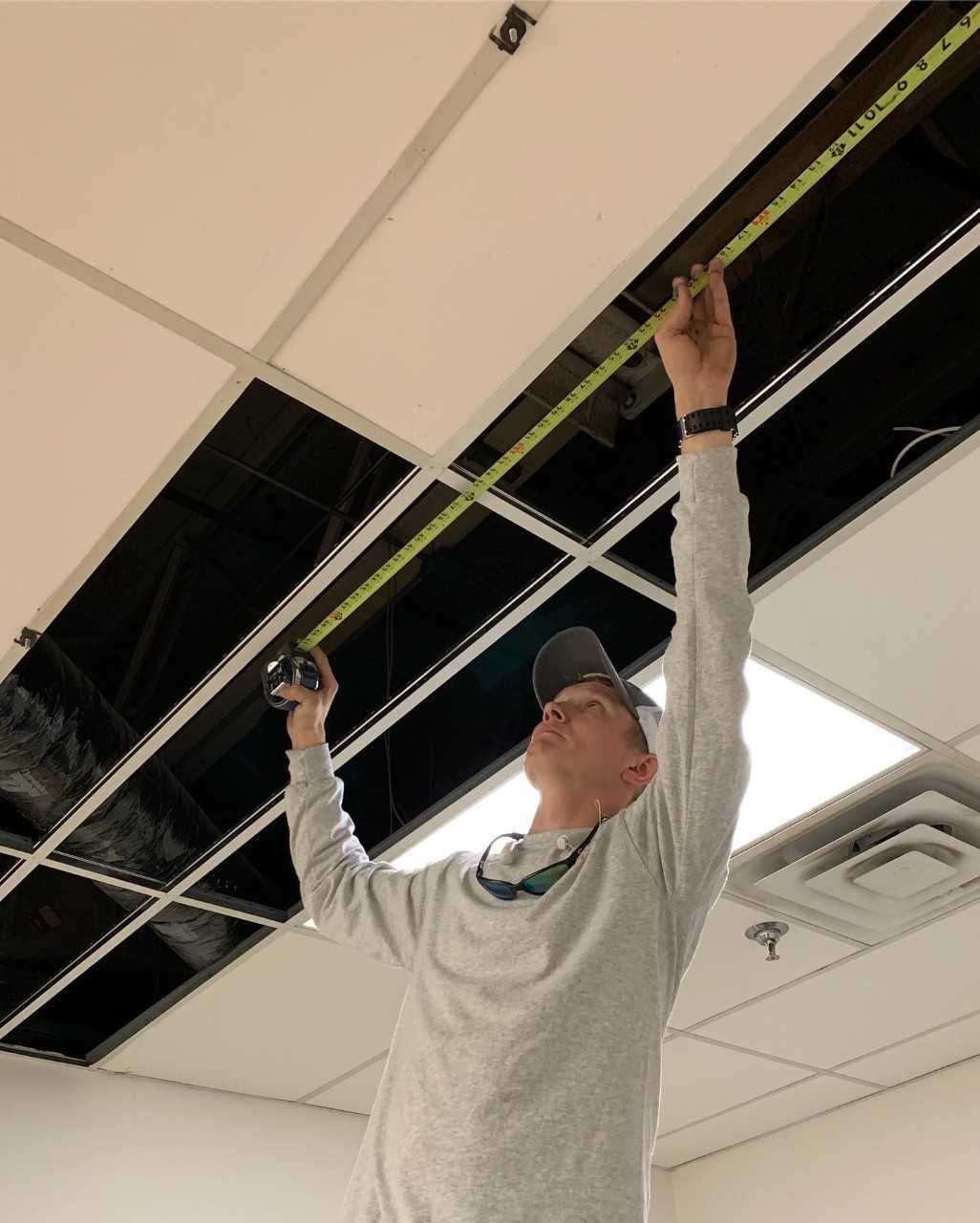 Maestro employee Dustin Kennedy repairing a ceiling for a client. Photo courtesy of Maestro Maintenance Management